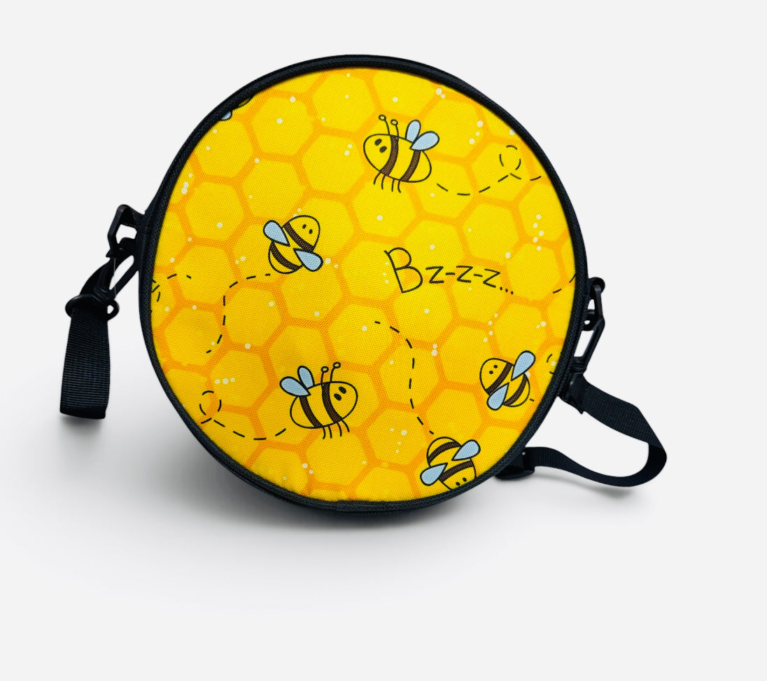 Yellow bee crossbody purse with honeycomb print and zip closure.