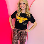 Black Bee Kind graphic tee with gold lamé and leopard appliqué accents on Bella Canvas.