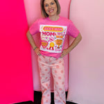 Pink graphic tee with Best Mom collage design, bright stickers, phrases, and bling accents