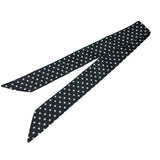 Black and white polka dot twilly scarf styled on neck and purse