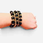 Black and gold beaded bracelet stack with glossy beads and comfortable stretch fit.