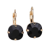 Gold tone drop earrings with faceted black gemstone and fishhook ear wire.