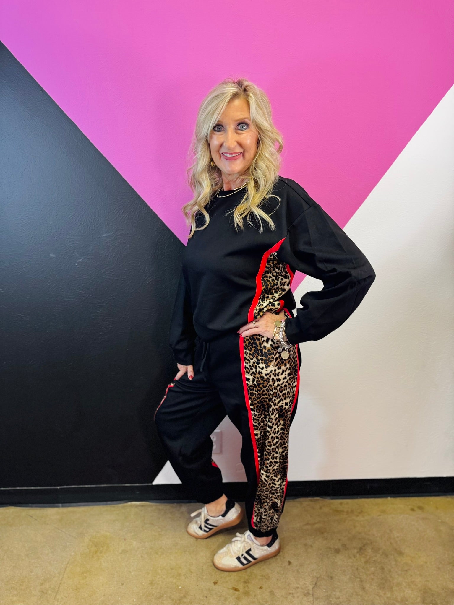 Black long sleeve pullover with leopard side panels, red piping, and banded hem.