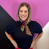 Black puff sleeve knit sweater with detachable leopard scarf neckline and bright red trim.