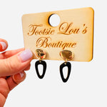 Hammered gold stud earrings with glossy black abstract drop shapes.