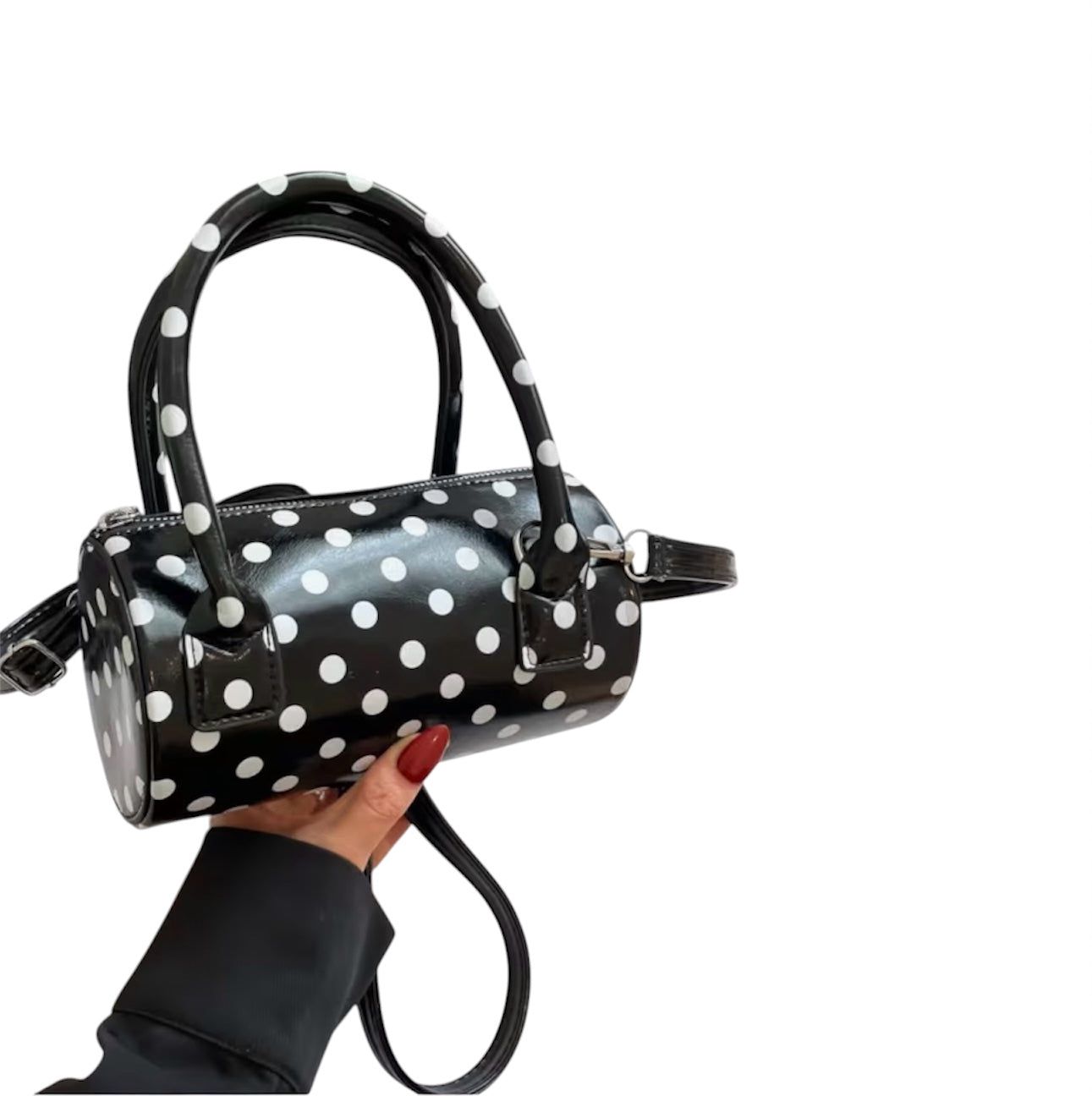 Black polka dot crossbody bag with top handles and adjustable strap.