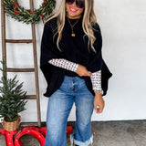 Black knit pullover poncho with relaxed fit, long arm openings, and cozy, flowy silhouette.