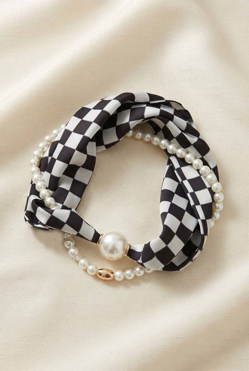 Black and white checkered scarf necklace with silky fabric and lustrous pearl accents.