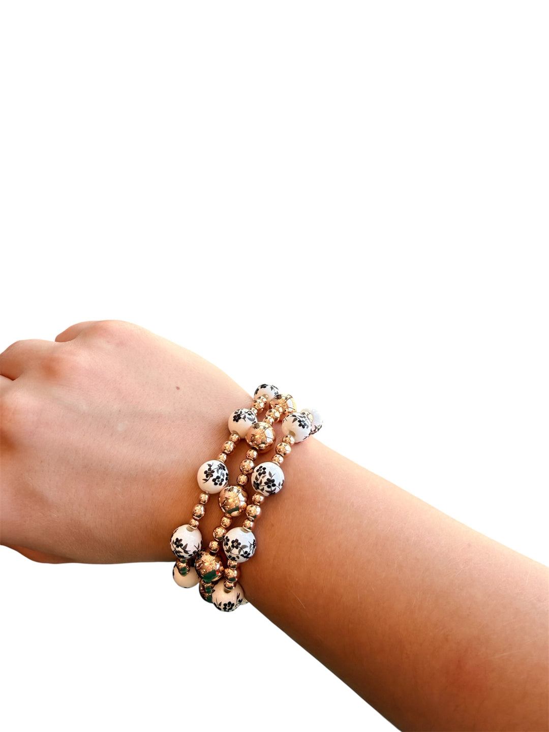 Water-resistant bracelet stack with glossy gold and black and white Chinoiserie beads.