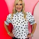 Black and white polka dot blouse with puff sleeves, ruffle neckline, and button-front detail.