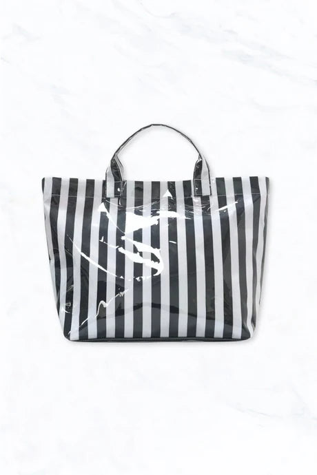 Black and white striped glossy waterproof tote bag with pink interior and pockets.