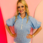 Blue gingham puff sleeve top with zip front and striped collar trim.