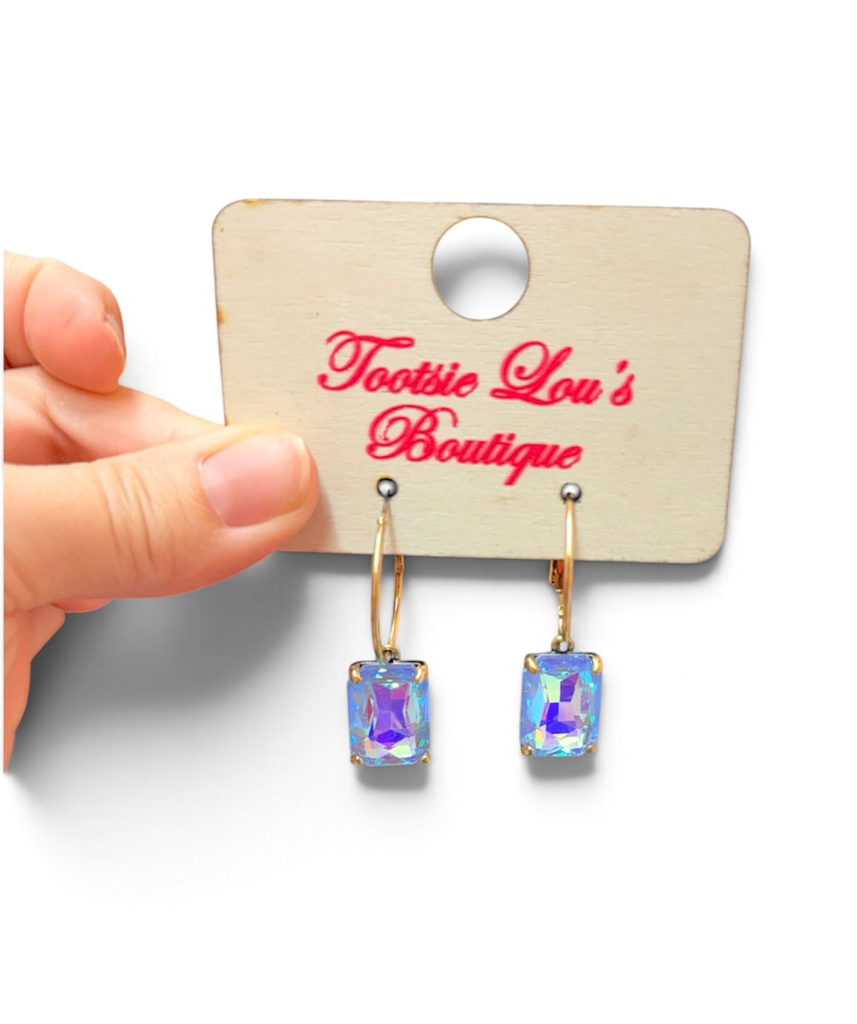 Gold-tone hoop earrings with faceted rectangular crystals reflecting iridescent blue tones.