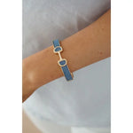 Denim hinge bangle bracelet with horsebit accent and polished hardware.
