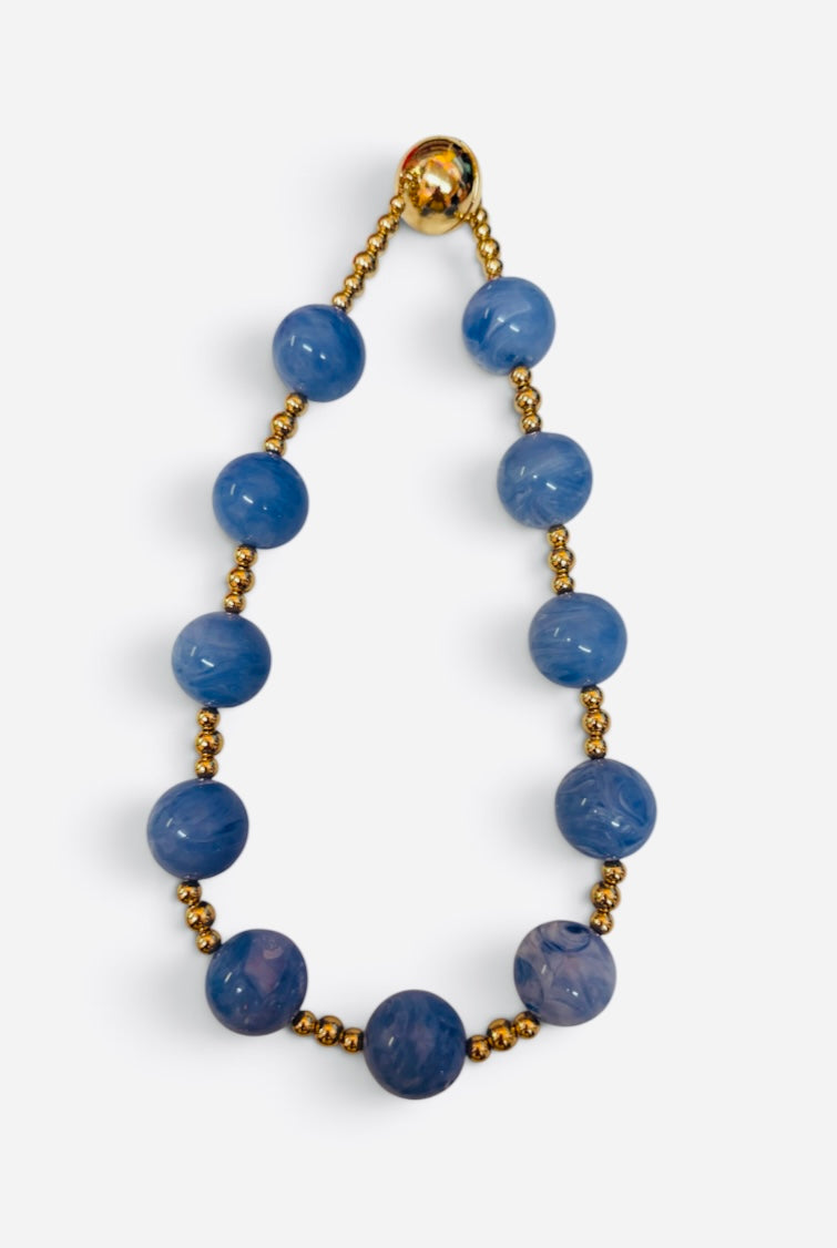 Blue marbled bead necklace with polished gold-tone accents and magnetic clasp.