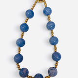 Blue marbled bead necklace with polished gold-tone accents and magnetic clasp.