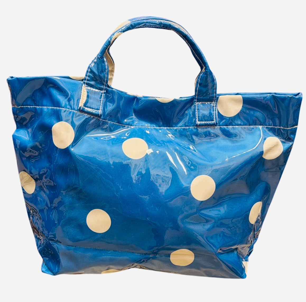 Blue polka dot tote bag with shiny finish and white dots.