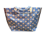 Cornflower blue PVC tote bag with white polka dots, navy sides, and sturdy handles.