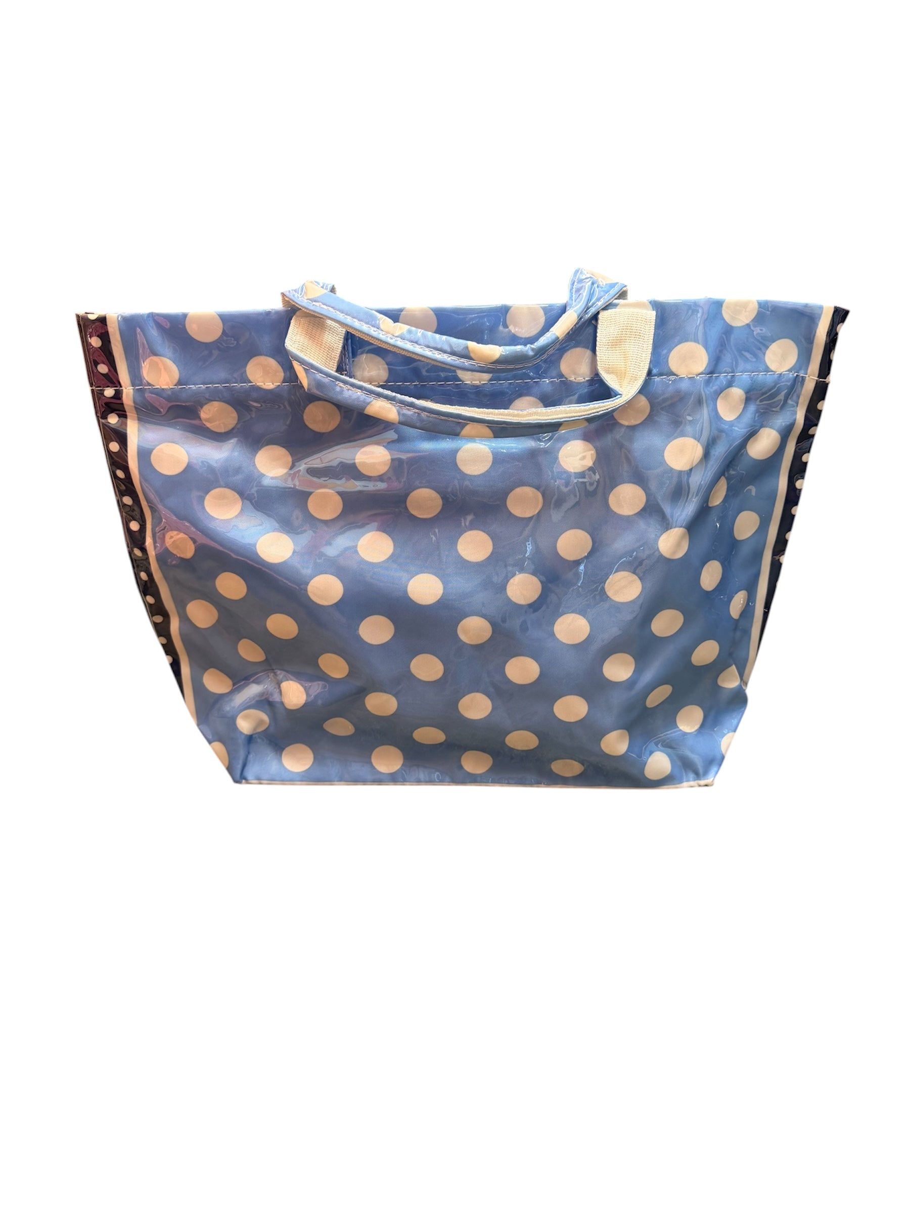 Cornflower blue PVC tote bag with white polka dots, navy sides, and sturdy handles.
