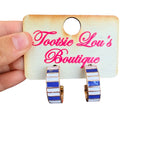 Blue and white striped enamel hoop earrings with polished gold-tone finish.
