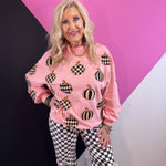 Pink pumpkin pullover with black and white checkered and striped pumpkins and sequin accents.