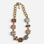 Chunky gold-tone link necklace with blush pink, amber, opalescent crystals, and rhinestone accents.