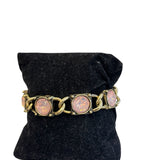 Antique gold tone bracelet with round pink stones and bold rounded links
