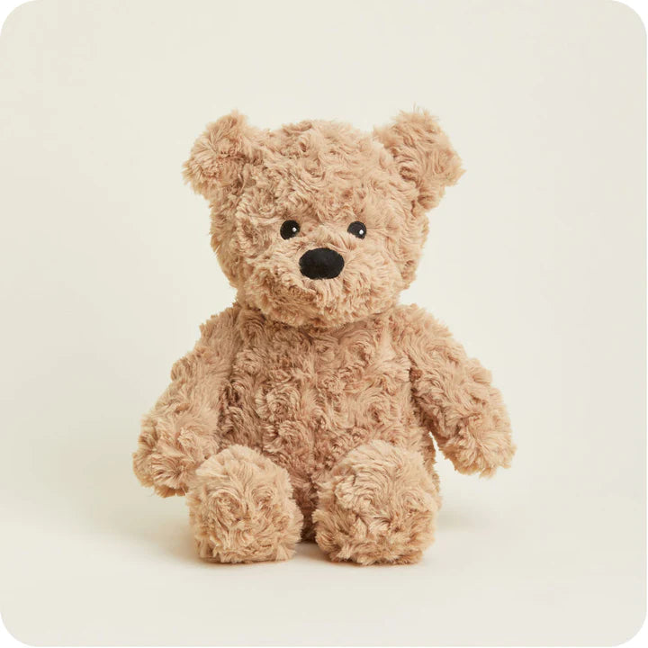 A soft, plush teddy bear with curly brown fur and a friendly face, designed to be microwavable.
