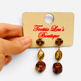 Brown and tan gemstone drop earrings with glossy beads and polished gold-tone settings.