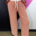 Burnt orange and white vertical striped ribbed lounge pants with drawstring waist.