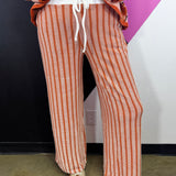 Burnt orange and white vertical striped ribbed lounge pants with drawstring waist.