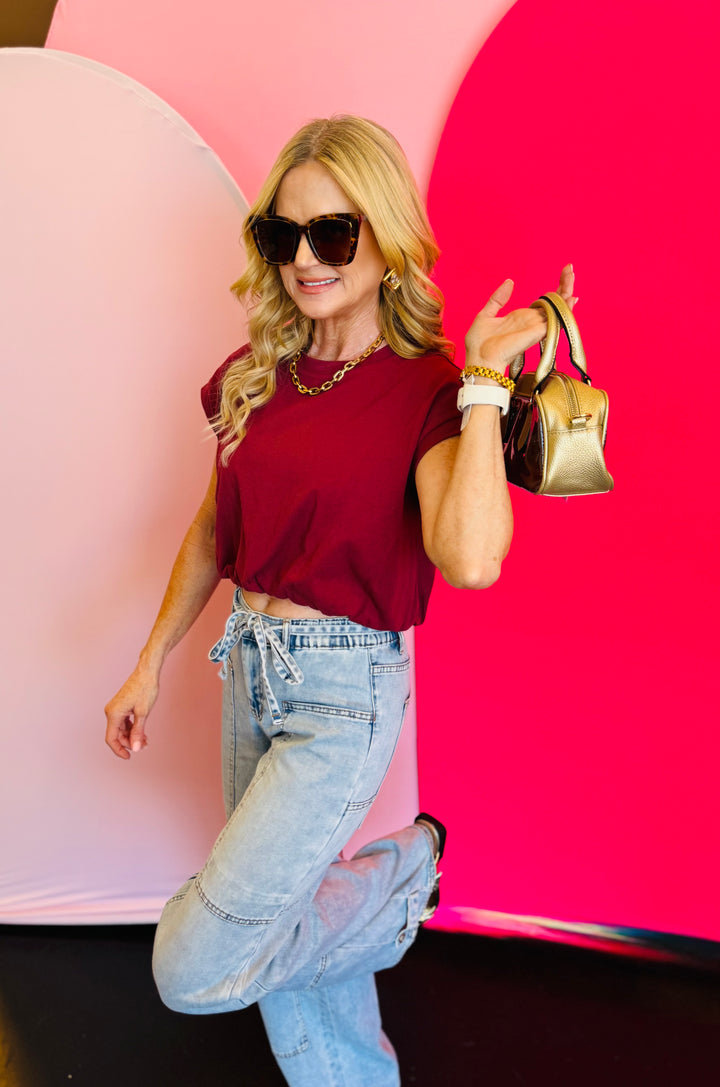 Side profile of the top worn by a model striking a playful pose, showing off the bubble hem.
