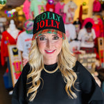 Black hat with “Holly Jolly” red and green embroidery and red-green-black-white plaid bill.