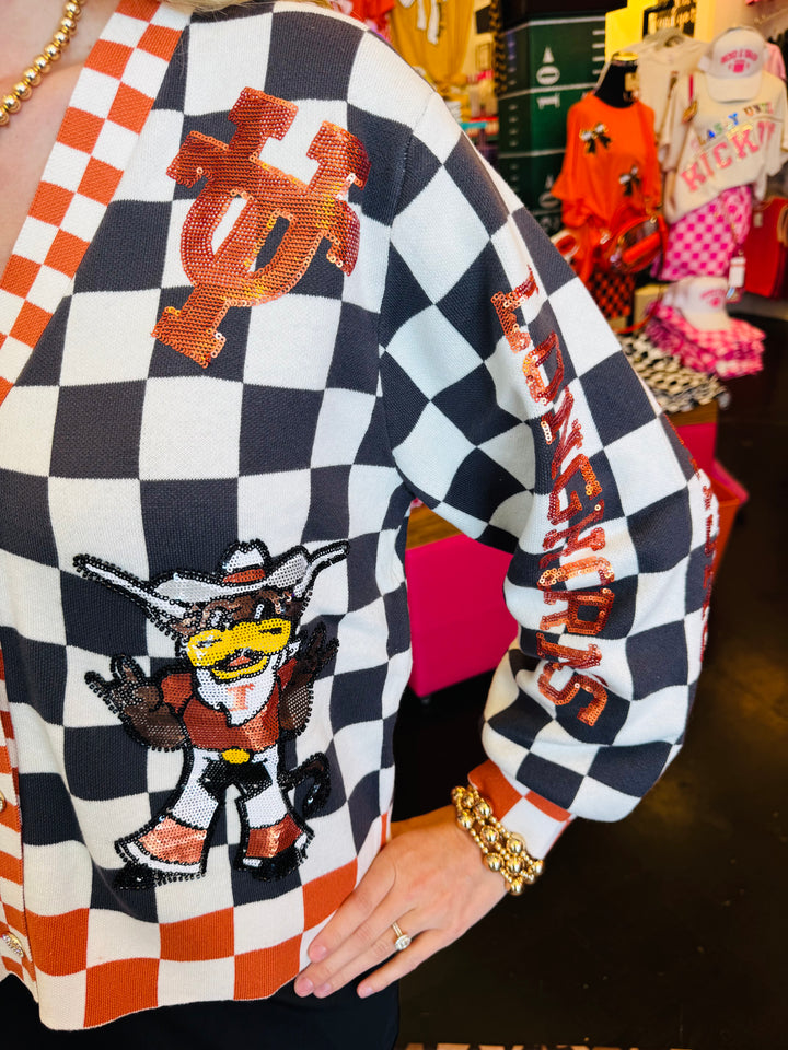 Close up Queen of Sparkles UT orange and black checkered cardigan with sequin and beading and rhinestone buttons.