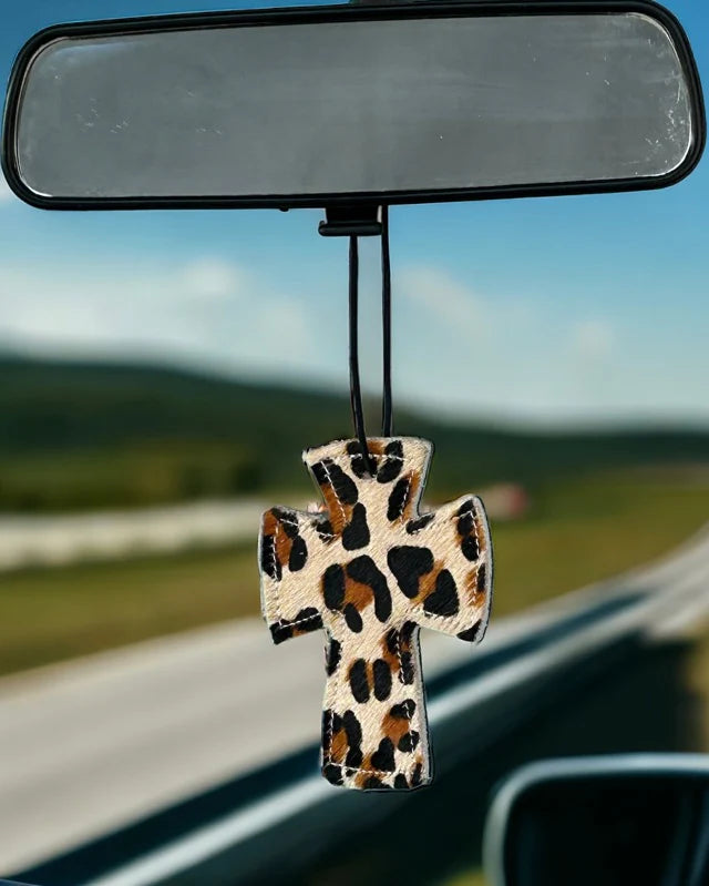 Cross-shaped hair-on-hide and leather car freshener charm, stitched design.