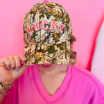 Camo hat with pink puff embroidered LUCKY lettering.