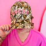 Camo hat with pink puff embroidered LUCKY lettering.