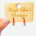 Glossy red enamel hoops with a single clear rectangular crystal accent.