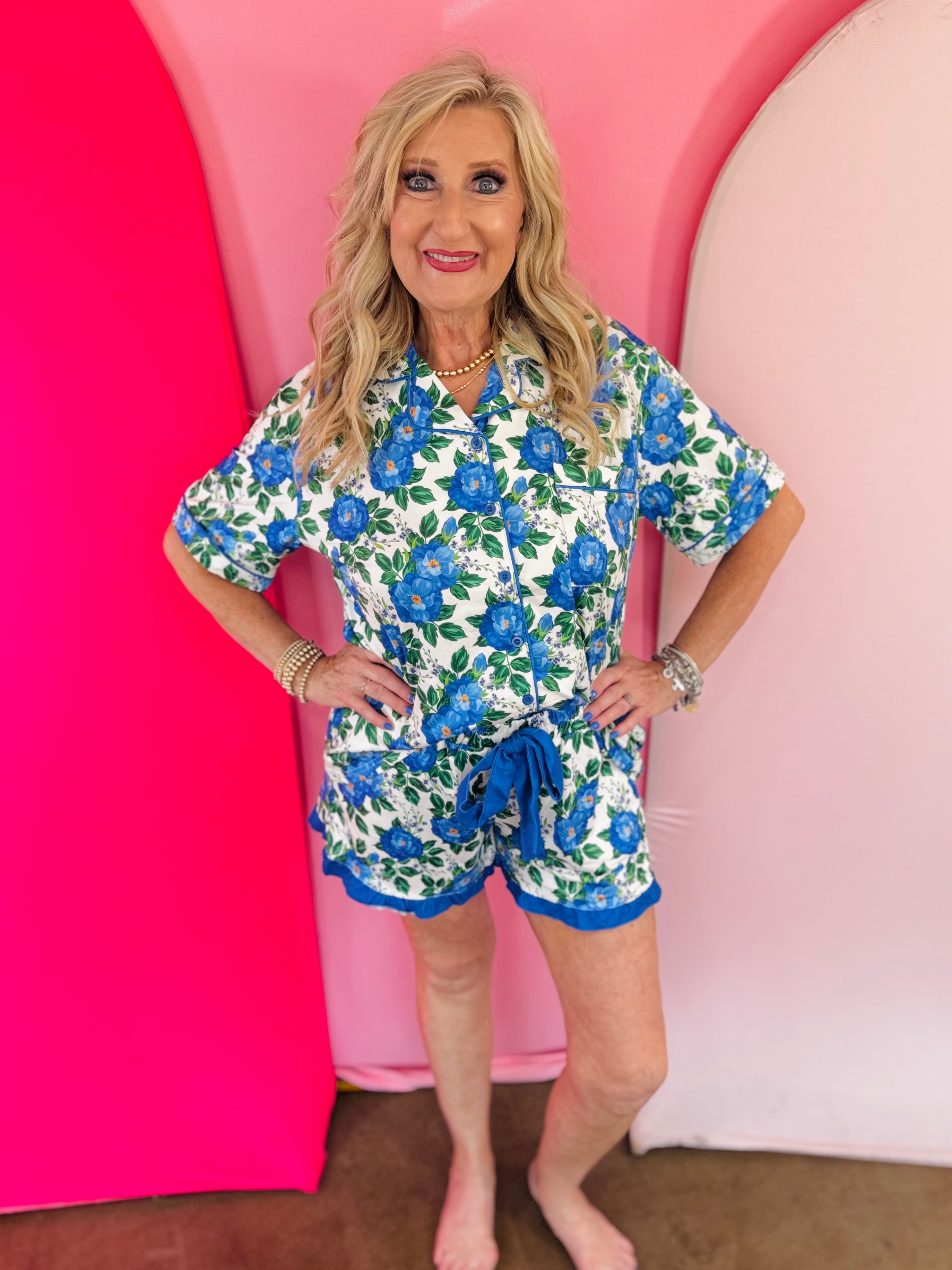 Blue floral pajama set with button-front top, ruffle shorts, and pockets.