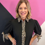 Black blouse with leopard trim and tie sleeves.