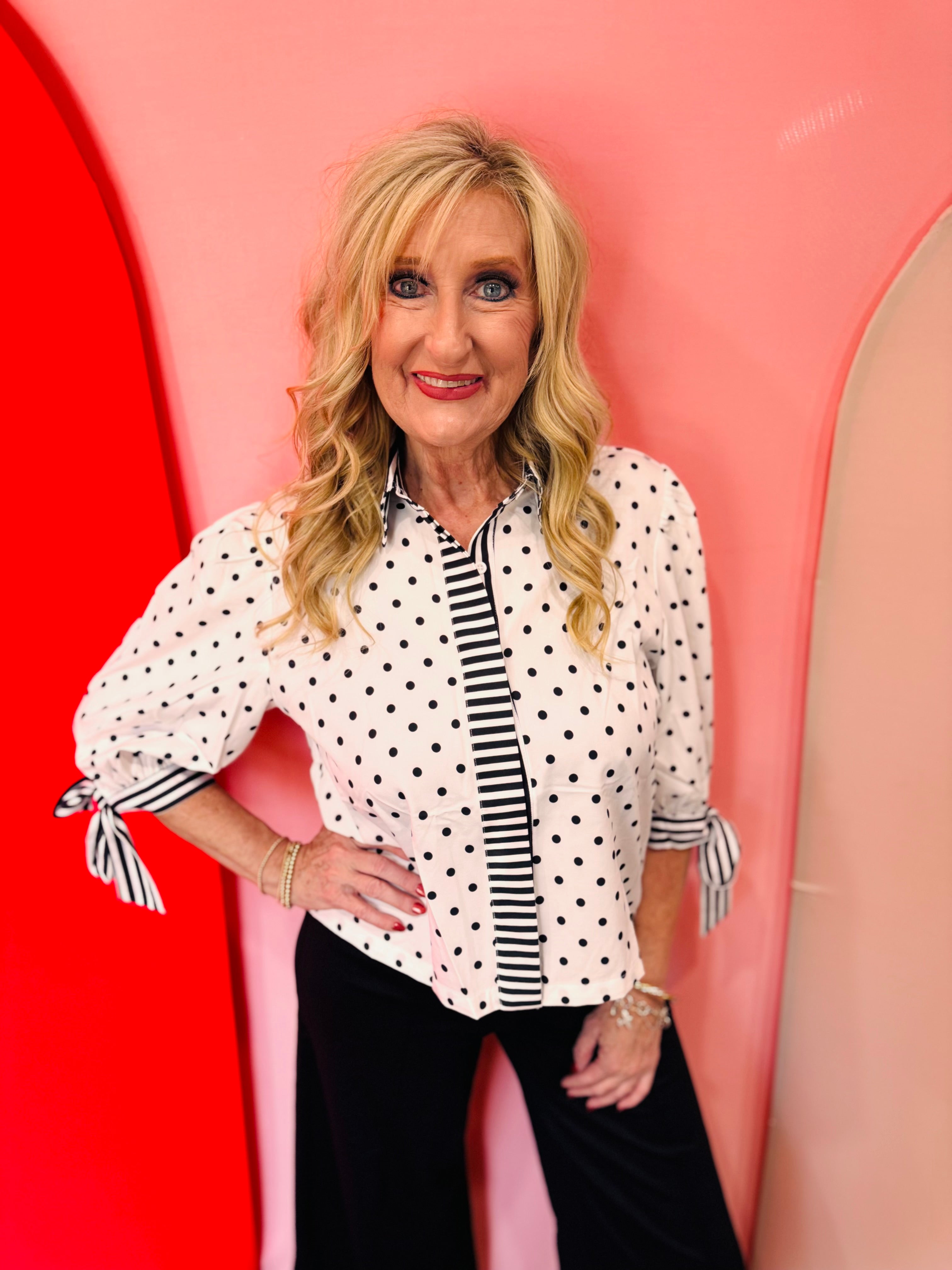 White polka dot blouse with striped trim and tie sleeves.