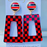 Red and black checkered acrylic dangle earrings with coordinating striped studs.