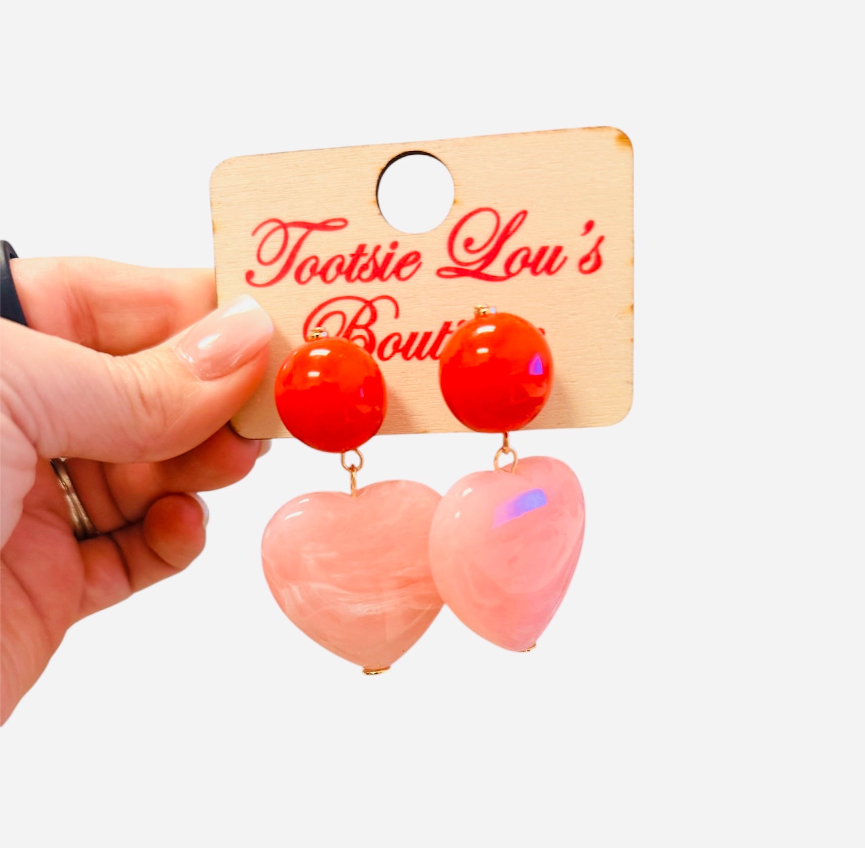 Red stud earrings with blush pink oversized heart drop.
