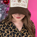 Tan, white, and chocolate corduroy hat with embroidered gingerbread cookie holiday design.