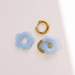 Matte light blue daisy hoop earrings with removable flowers and gold hoop.