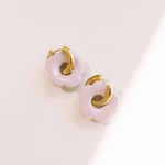 Matte pink daisy hoop earrings with removable flowers and gold hoop design.