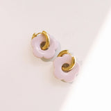 Matte pink daisy hoop earrings with removable flowers and gold hoop design.