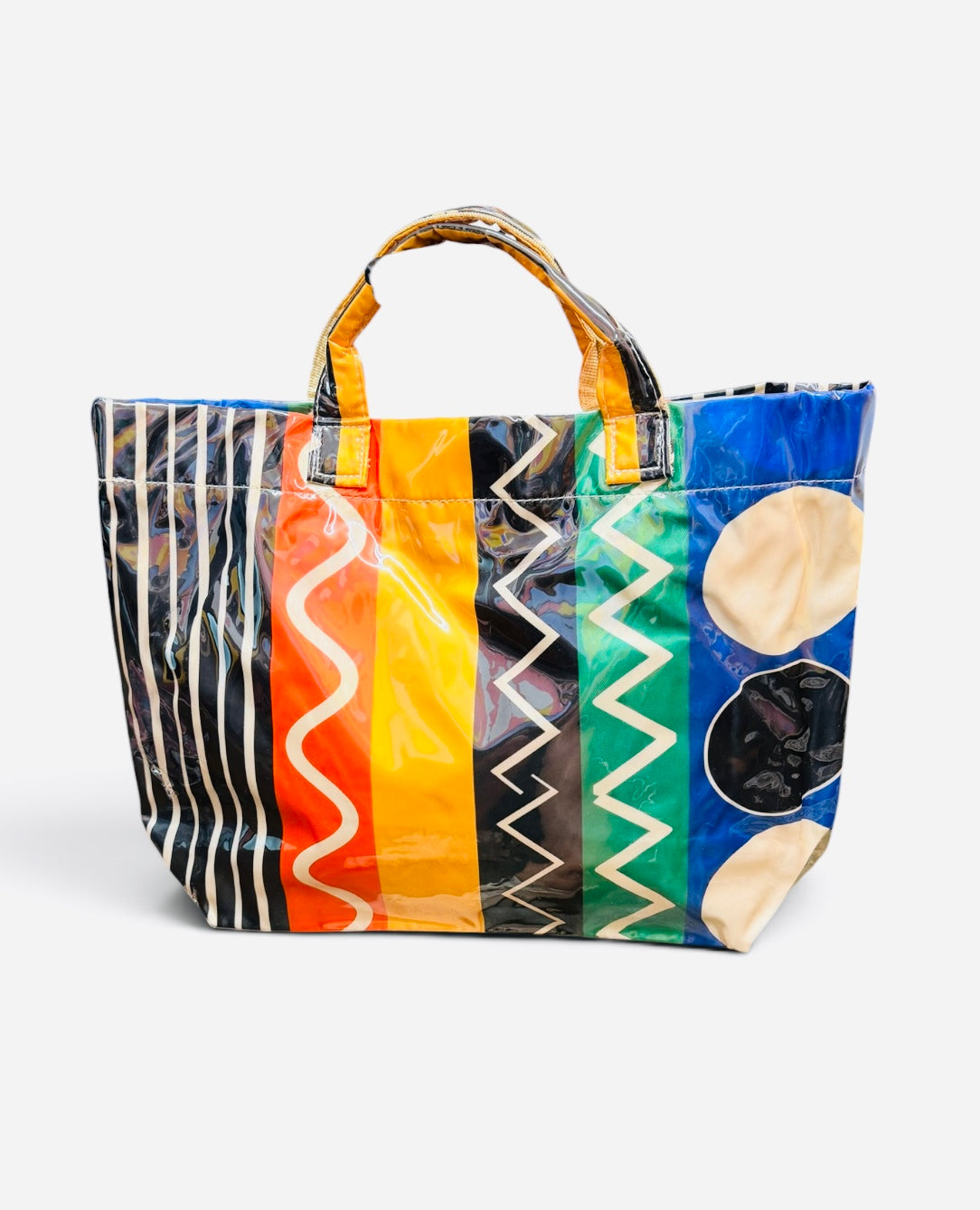 Colorful PVC tote bag with stripes, squiggles, zigzags, polka dots, and colorblock patterns.