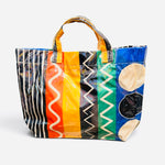 Colorful PVC tote bag with stripes, squiggles, zigzags, polka dots, and colorblock patterns.