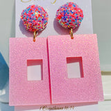 Pink glitter square earrings with sparkling multicolor confetti-style round studs.